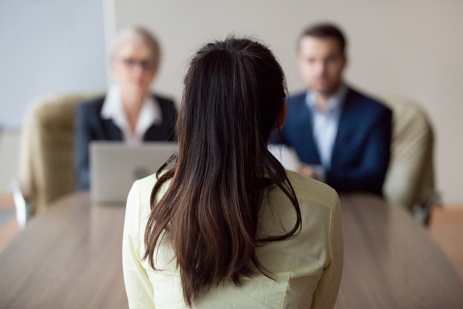 Businesswoman and businessman HR manager interviewing woman.